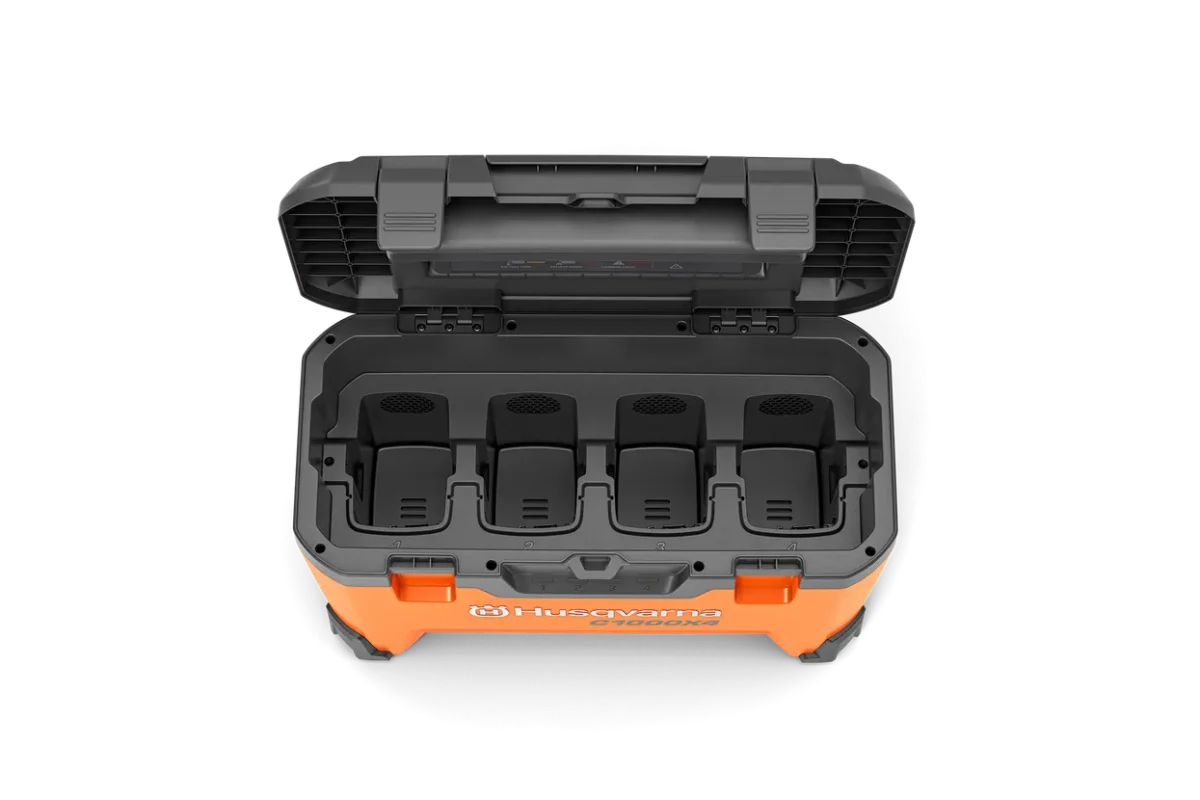 Top view of Husqvarna 40-C1000X4 battery charger showing four empty battery slots inside an open lid.